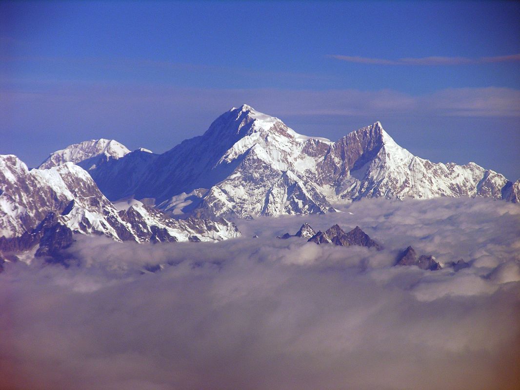 Shishapangma 01 01 Kangchenjunga 01 04 Mountain Flight Shishapangma Long View Shishapangma, the 14th highest mountain in the world at 8012m, shines in the early morning sun from Kathmandus Mountain flight. The steep and treacherous southwest face is in shadow on the left. The north face is just visible in the sun on the right. On the far right the pointy rocky peak is Phola Gangchen (7716m), first climbed in 1981, and to its left is Shishapangmas East face.